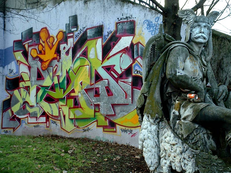 Denkmal eines Schwertk&auml;mpfers vor Betonwand mit Graffity
